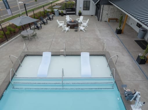a swimming pool with chairs and tables around it at Sonder Fields in Happy Valley, OR