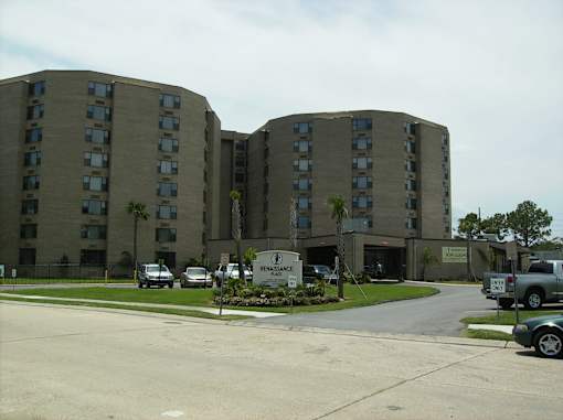 A Renovance Apartment complex with a parking lot in front.