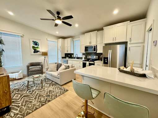 A modern kitchen with a white countertop and a ceiling fan.