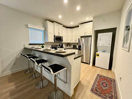 A kitchen with a refrigerator, microwave, and oven.