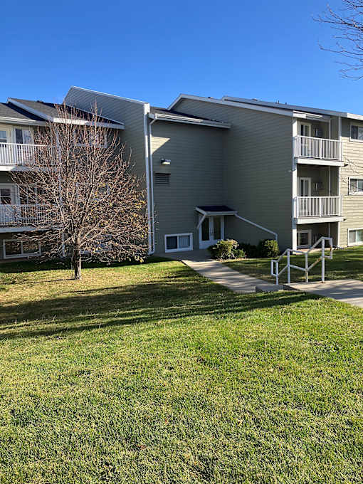 Apartment building with a tree in front of it.
