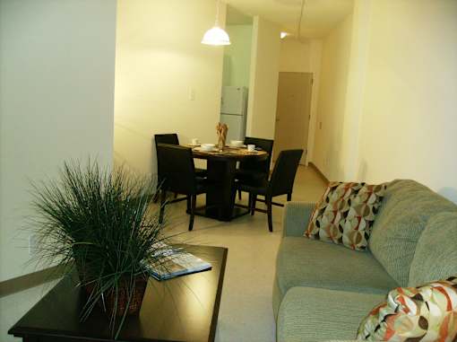 A living room with a couch, chairs, and a dining table.