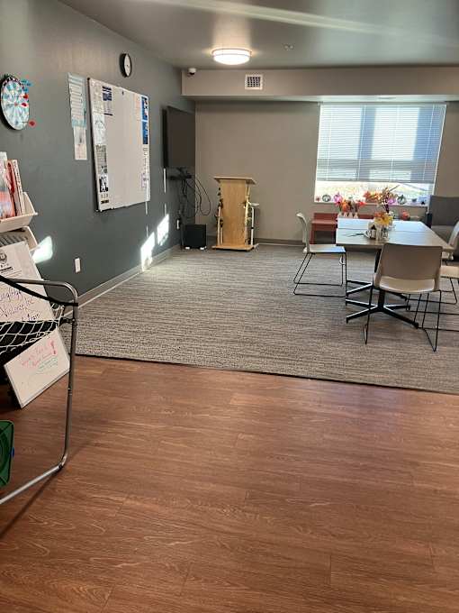 A conference room with a whiteboard and a clock on the wall.