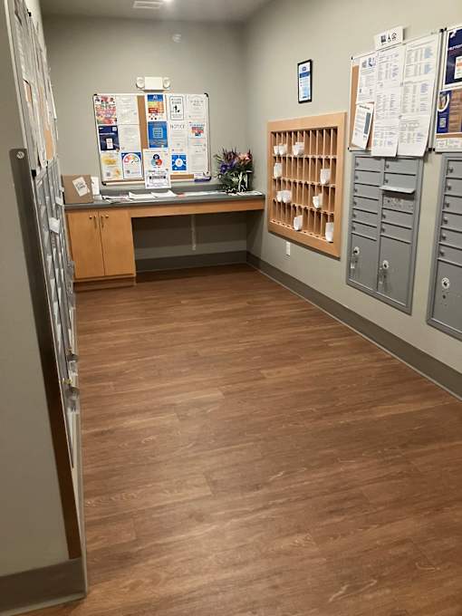 A room with a wooden floor and a whiteboard on the wall.