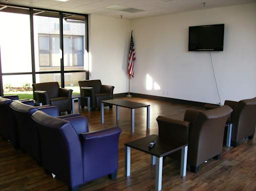 A room with purple chairs and a flat screen TV mounted on the wall.