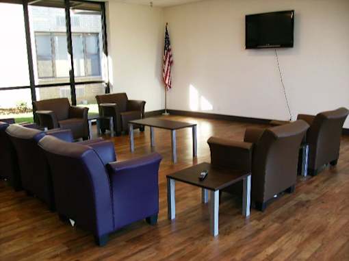 A room with a wooden floor and a television mounted on the wall.