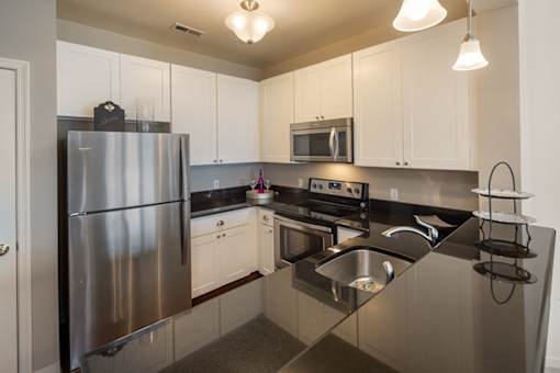A modern kitchen with a stainless steel refrigerator and a microwave above the stove.