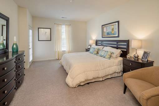 A bedroom with a large bed and a dresser.