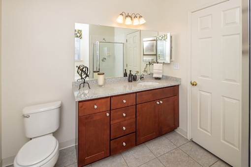 A bathroom with a toilet, sink, and mirror.