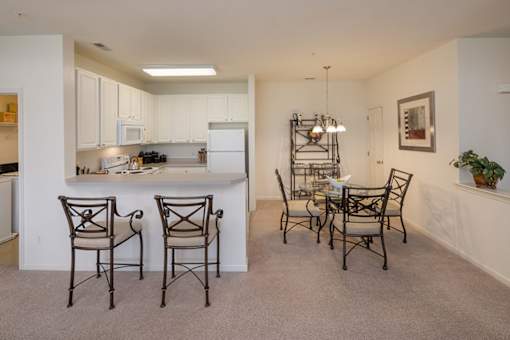 A kitchen with a dining table and chairs.