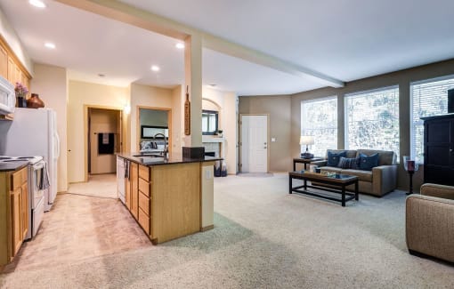 a living room with a kitchen and a couch at Madison Sierra Sun, Puyallup, Washington