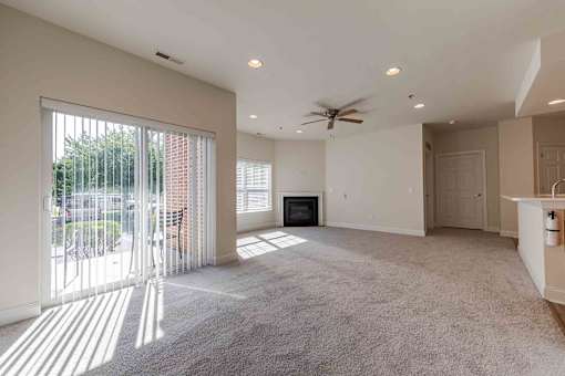 A spacious living room with a fireplace and sliding glass doors.