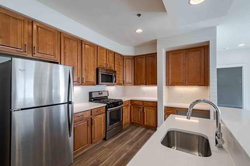 A renovated kitchen with wooden cabinets and a stainless steel refrigerator.