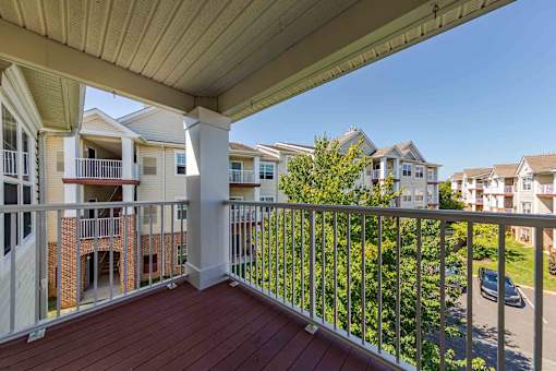A balcony with a white railing and a red floor.
