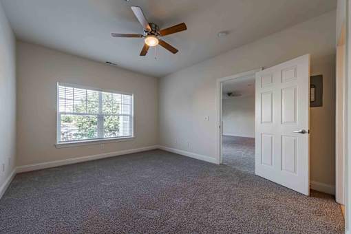 A room with a ceiling fan and a window.