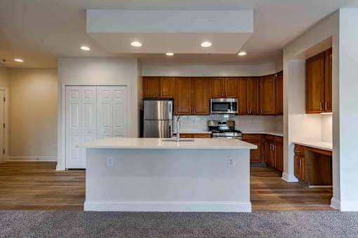A kitchen with wooden cabinets and a white island.