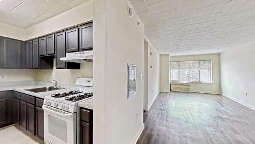 A kitchen with a white stove and black cabinets.