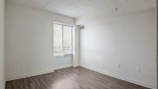 A room with wooden flooring and a window.