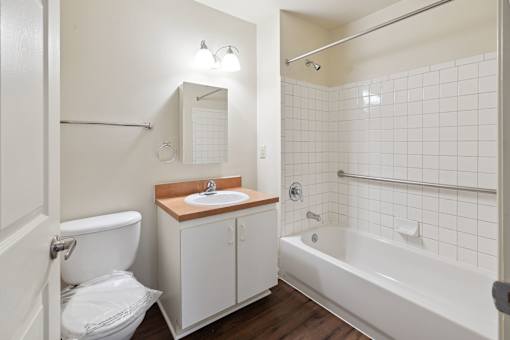 A white bathroom with a toilet, sink, and bathtub.