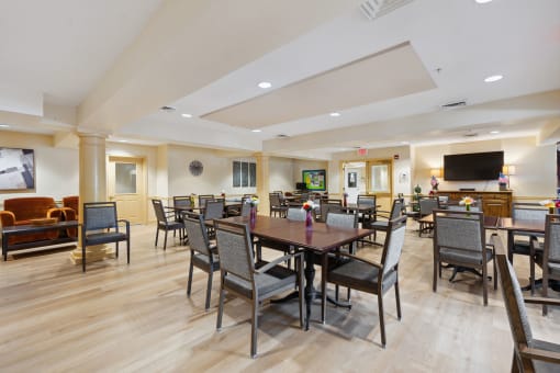 a large room with a large table and chairs and a flat screen tv on the wall