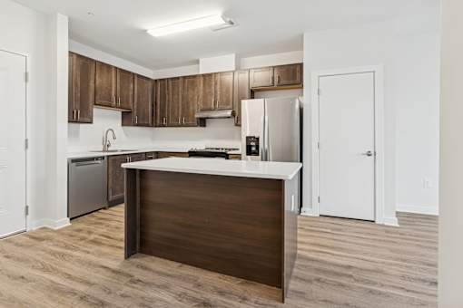 A kitchen with a white counter top and wooden cabinets.
