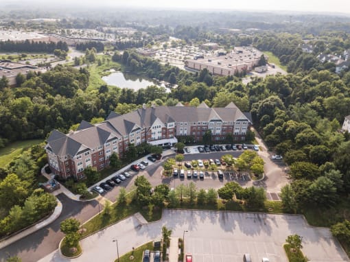 an aerial view of a large building surrounded by trees and a parking lot