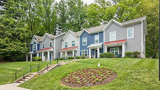 A row of houses with a flower bed in the front.