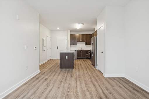 A kitchen area with a refrigerator, sink, and cabinets.