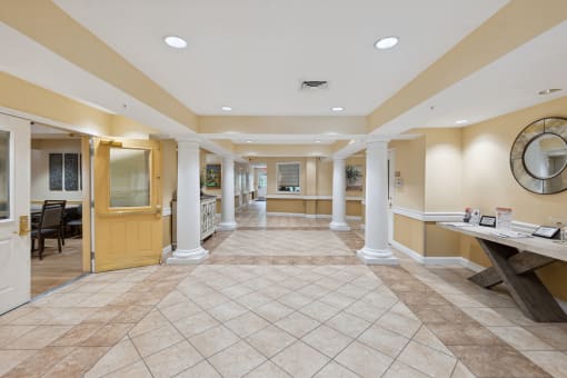 a lobby with a table with a mirror on the wall