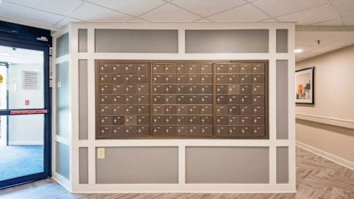 A wall of brown mailboxes in a hallway.