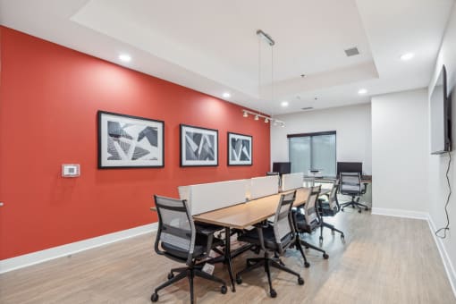 Legacy at Twin Rivers conference room with a long table and chairs and a red accent wall