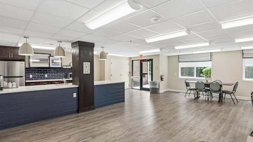 A kitchen area with a dining table and chairs.