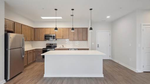 A modern kitchen with wooden cabinets and a white island.