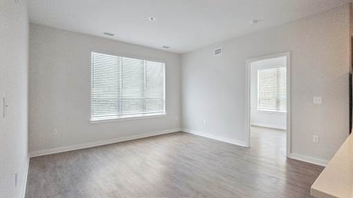 A spacious room with a window and a door.