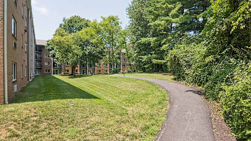 A pathway leads through a grassy area between two rows of buildings.