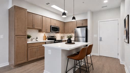A kitchen with brown cabinets and a white island.