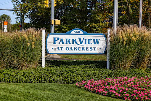 A sign for Park View at Oakcrest stands in a field of flowers.