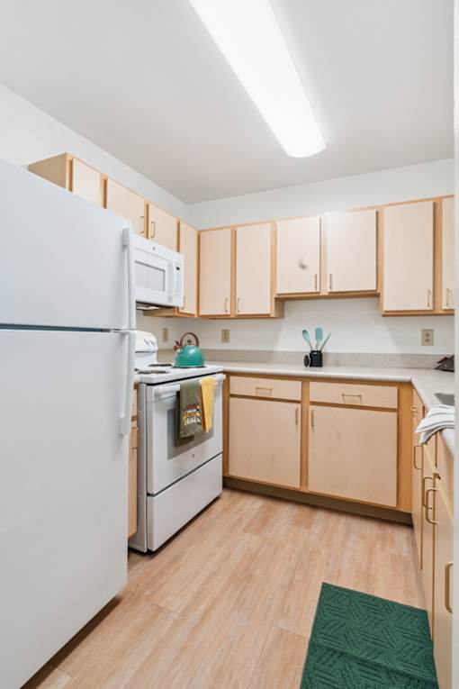 A kitchen with wooden cabinets and a white refrigerator.