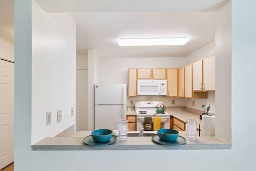 A kitchen with a white fridge and wooden cabinets.