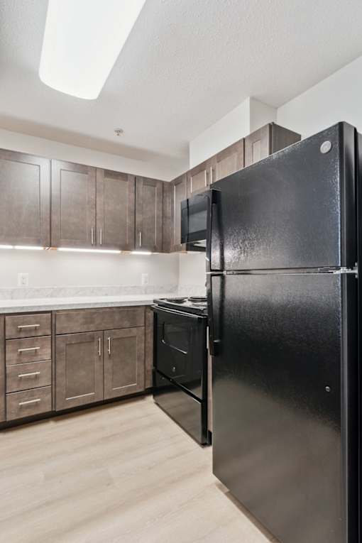 Updated senior apartment kitchen at Park Heights Place in Baltimore, featuring modern appliances, ample counter space, and stylish cabinetry for comfort and convenience.