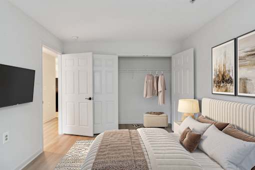 Cozy senior apartment bedroom at Park Heights Place with soft lighting, generous closet space, and warm, inviting décor.