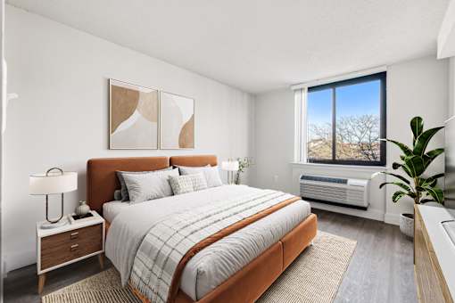 Bright, airy bedroom in a market-rate 2-bedroom apartment at Edgewood Commons 611 & Gardens, with generous closet space, luxury vinyl flooring, and plenty of natural light—ideal for comfort and rest.