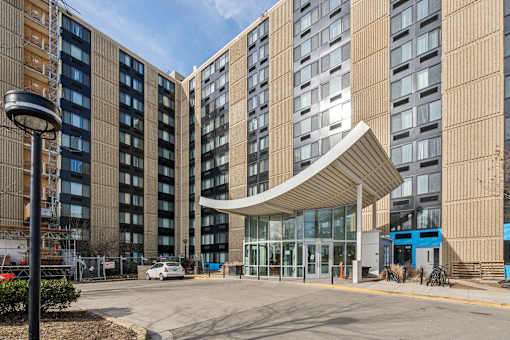 Exterior view of Edgewood Commons 611 & Gardens, a modern high-rise and garden-style apartment community in Northeast Washington, D.C., offering market-rate 1- and 2-bedroom homes. The building features landscaped grounds, convenient access to public transportation, and a welcoming atmosphere near Rhode Island and Brookland Metro stations.
