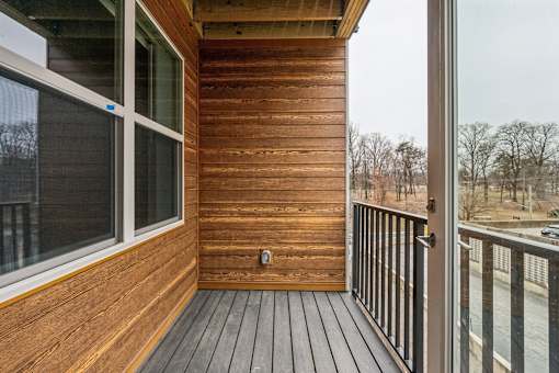 A wooden deck with a glass door and a window.