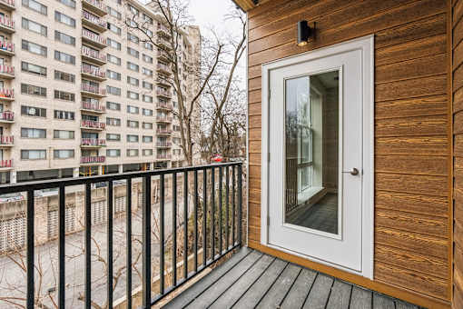 A balcony with a white door and a black railing.