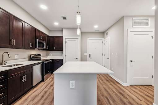 A kitchen with dark brown cabinets and a white island.