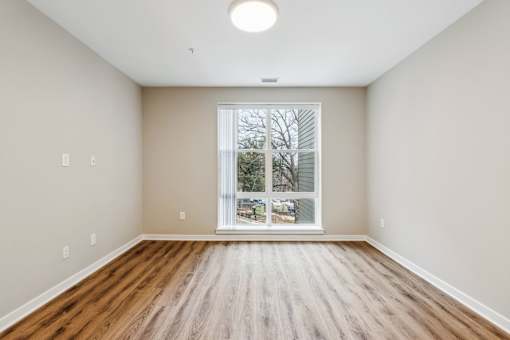 A room with wooden floors and a large window.