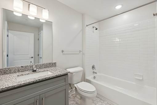 A white bathroom with a sink, toilet, and bathtub.