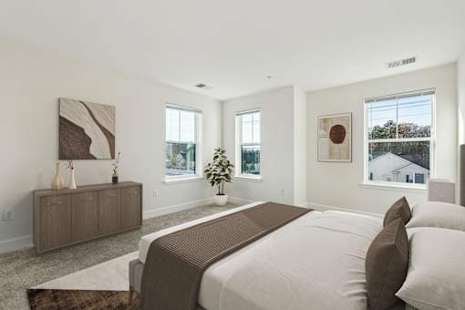 A bedroom with a large bed and a wooden cabinet.