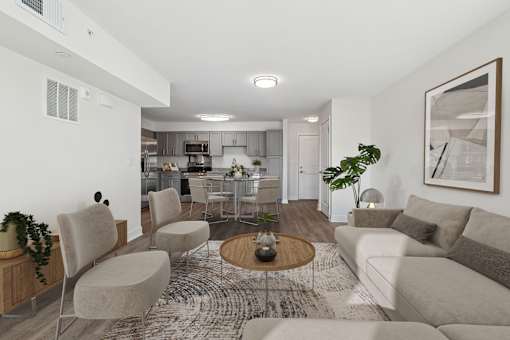 A modern living room with a grey couch, a coffee table, and a kitchen in the background.